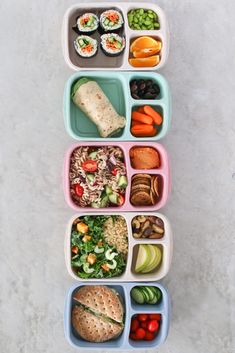 several trays filled with different types of food on top of a white countertop