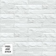 a white brick wall with peel and stick on the bottom corner, next to a sign that says peel and stick