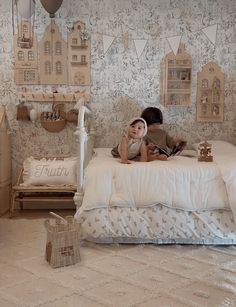 two children laying on a white bed in a room with wallpapered walls and flooring