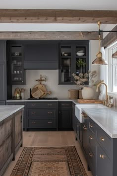 a kitchen with dark gray cabinets and white counter tops, gold accents on the trim