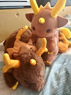 a stuffed animal sitting on top of a bed next to another stuffed animal with horns