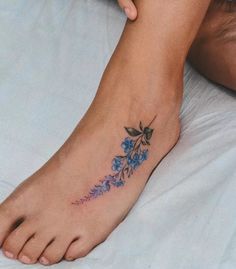 a woman's foot with blue flowers on it