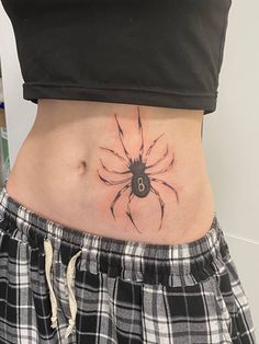 a woman's stomach with a spider tattoo on her lower body and bottom part