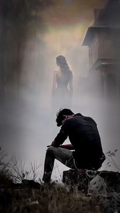 a man kneeling down next to a woman in the fog