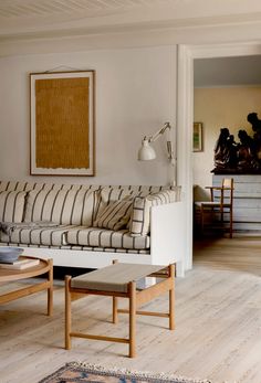 a living room filled with furniture and a painting on the wall