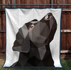 a black dog is depicted on a white quilt