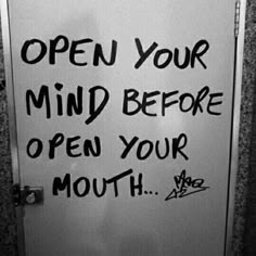 an open door with graffiti on it and the words open your mind before open your mouth