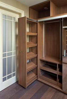 an empty closet with wooden shelves and sliding doors