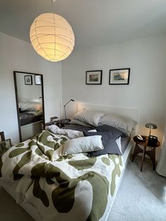 a bedroom with a bed, mirror and lamp on the wall next to each other