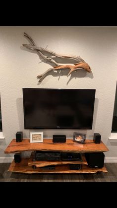 a flat screen tv sitting on top of a wooden stand in front of a wall