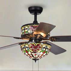 a ceiling fan with stained glass shades hanging from it's blades and light fixture