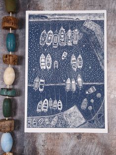 a blue and white print with boats on the water in front of some wood pegs