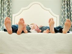 two children laying on top of a bed with their feet propped up in the air