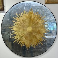 a circular glass display with gold foiled sunbursts on it's side