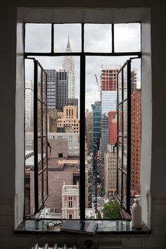 an open window shows the city skyline and skyscrapers