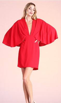 Whether you're going to a wedding, gala, shower or Holiday party, this amazing cape dress will be sure to wow the crowd! This dress features a gathered, tuck-pleat v neckline, cape design on the shouldersback and a mini length. Pair with strappy heels and a clutch for an elegant, timeless look. Flowy V-neck Mini Dress For Formal Occasions, Chic V-neck Mini Dress For Wedding Guest, Pre-draped Cape Evening Dress, Glamorous V-neck Dress With Draped Sleeves, Spring V-neck Dresses With Structured Shoulders, Spring Date Night Dresses With Draped Sleeves, Party Dresses With Draped Sleeves And V-neck, Flowy Draped Evening Dress, Elegant Flutter Sleeve Dresses For Date Night