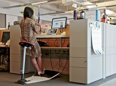 a woman standing on an electric scooter in an office