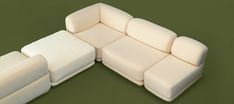 a white couch sitting on top of a green floor