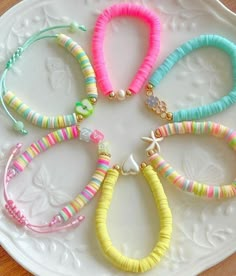 several bracelets are arranged on a white plate