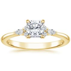 a yellow gold engagement ring with an oval cut diamond in the center and two pear shaped diamonds on each side