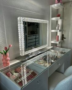 a vanity with a mirror, stools and pink flowers