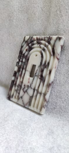 a white and black object sitting on top of a gray floor next to a wall