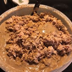 a pan filled with food sitting on top of a stove next to a spatula