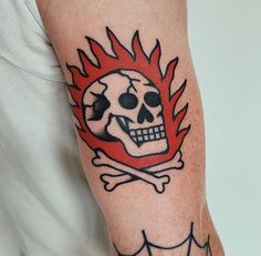 a man with a skull and crossbone tattoo on his arm