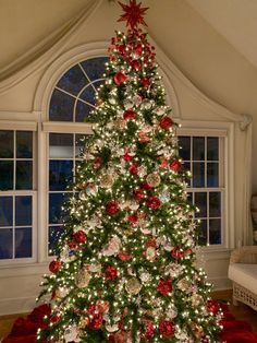 a decorated christmas tree in front of a window