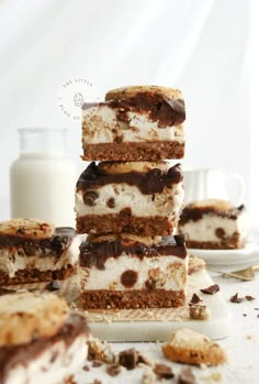 several pieces of dessert stacked on top of each other next to a bottle of milk