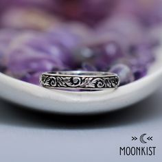 a silver ring sitting on top of a white plate