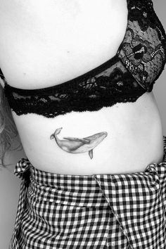 a woman with a tattoo on her stomach and a whale in the bottom right side