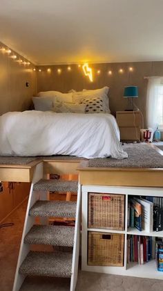 a bedroom with stairs leading up to the bed and bookshelves in front of it