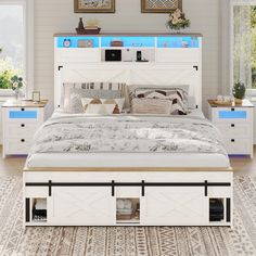 a white bed with drawers underneath it and pictures above the headboard on the wall