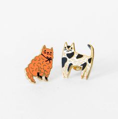 two pins with cats on them sitting next to each other