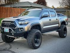 a silver toyota truck parked in front of a house