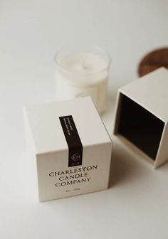 a white box sitting on top of a table next to a candle