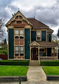 an old victorian style house with green trim