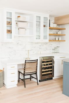 a kitchen with white cabinets and wooden floors, an oven built into the back wall