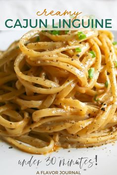 a white plate topped with pasta covered in parmesan cheese and green onion garnish