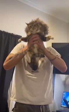 a man holding a cat up to his face