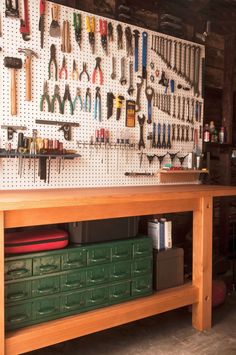 the workbench is full of tools, including hammers and wrenches on the wall