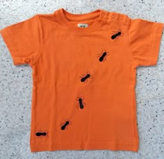 an orange shirt with black bugs on it