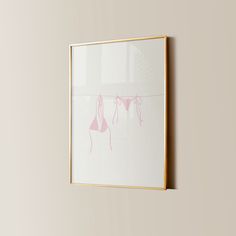 a framed photograph hanging on the wall next to a vase with pink flowers in it