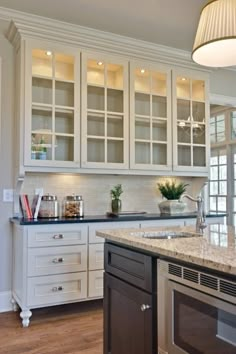 a kitchen with white cabinets and granite counter tops