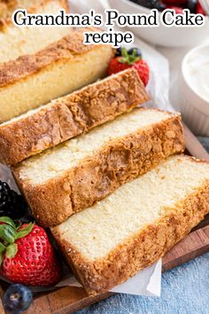 two slices of pound cake on a cutting board with berries and cream in the background