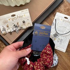 a person holding a tie in their hand next to harry potter jewelry