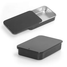 two black and silver containers on a white surface with one empty container in the middle