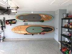 two surfboards mounted to the wall in a garage