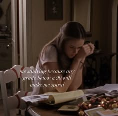 a woman sitting at a table in front of a plate of food with the words, not studying because any grade below her